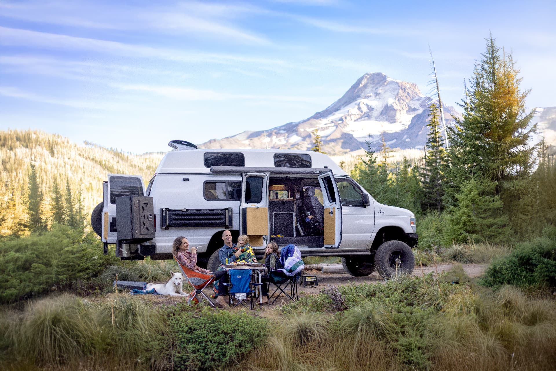 Our family sitting outside our camper van with Mt. Hood behind us