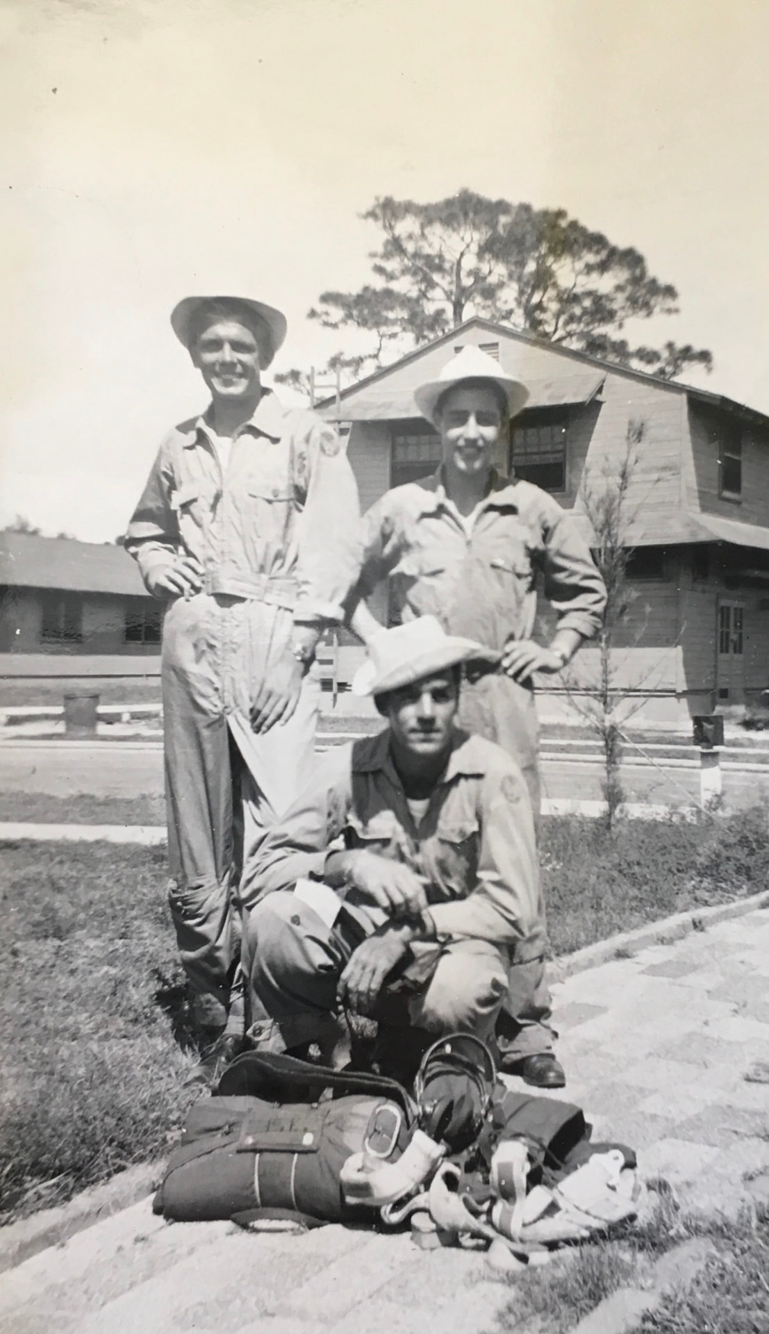 My grandfather with two crewmates in flight suits outside the barracks